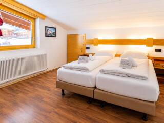16. Catered chalet Alber Sankt Anton Slaapkamer met gouden tinten